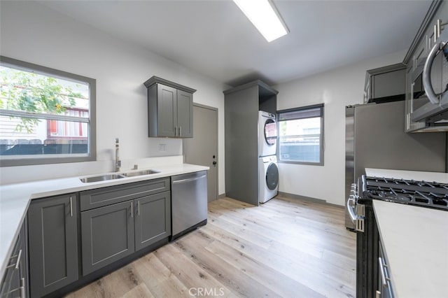 532 W 5th St, Long Beach, CA 90802 - kitchen featuring stacked washer / drying machine, light wood-type flooring, stainless steel appliances, light countertops, and gray cabinetry