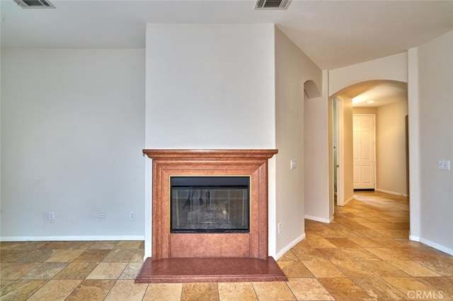 1660 Snowberry Rd, Beaumont, CA 92223 - unfurnished living room featuring arched walkways, light stone finish floors, and a glass covered fireplace