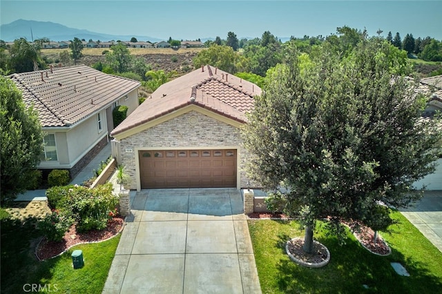 1660 Snowberry Rd, Beaumont, CA 92223 - view of front facade featuring stone siding, driveway, an attached garage, a tile roof, and a front yard