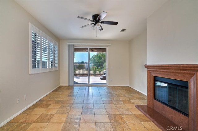 1660 Snowberry Rd, Beaumont, CA 92223 - unfurnished living room with ceiling fan, a glass covered fireplace, and light stone finish flooring