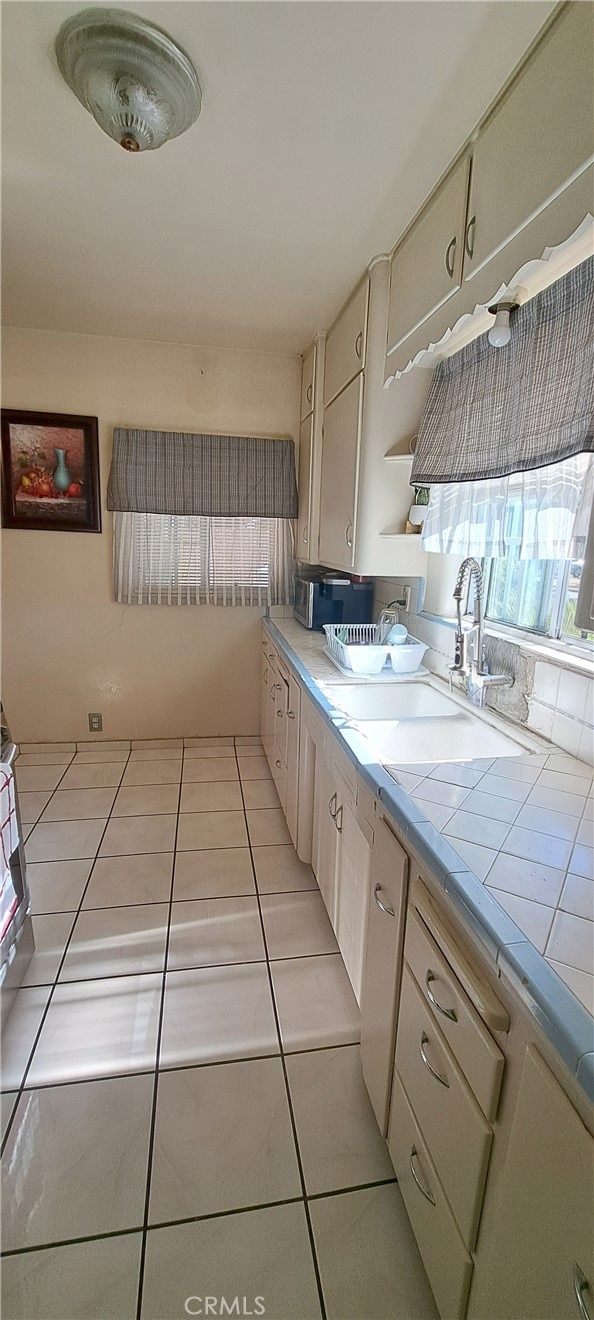 1605 S Birch St, Santa Ana, CA 92707 - kitchen with tile counters, light tile patterned floors, and stainless steel microwave