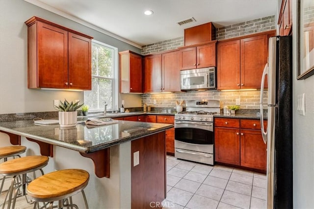 3591 Sacramento Dr Unit 208, San Luis Obispo, CA 93401 - kitchen with stainless steel appliances, a peninsula, backsplash, light tile patterned floors, and a kitchen breakfast bar