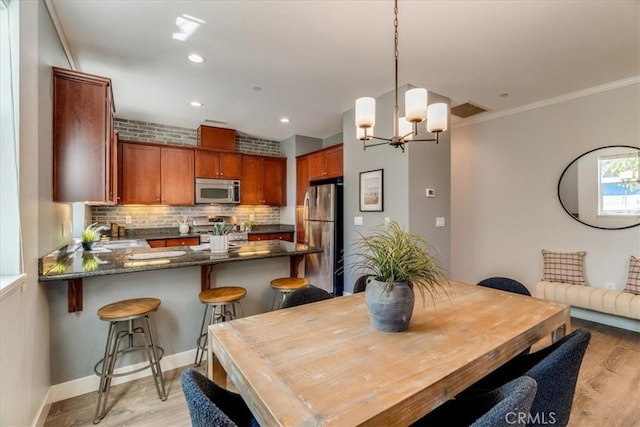 3591 Sacramento Dr Unit 208, San Luis Obispo, CA 93401 - dining area featuring light wood-type flooring, a chandelier, recessed lighting, and crown molding