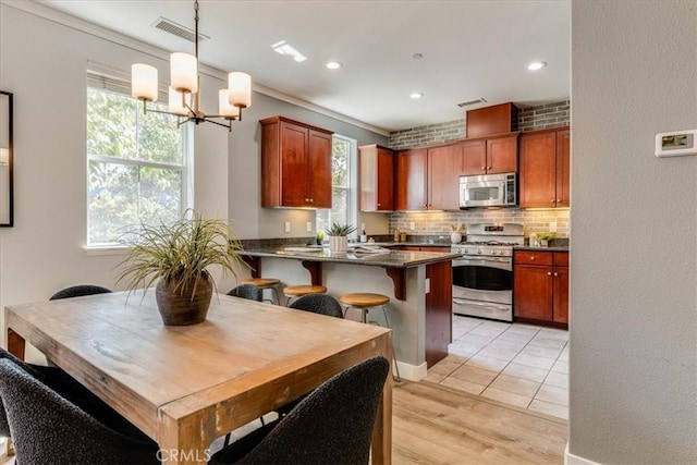 3591 Sacramento Dr Unit 208, San Luis Obispo, CA 93401 - kitchen with stainless steel microwave, gas range, dark countertops, backsplash, and a chandelier