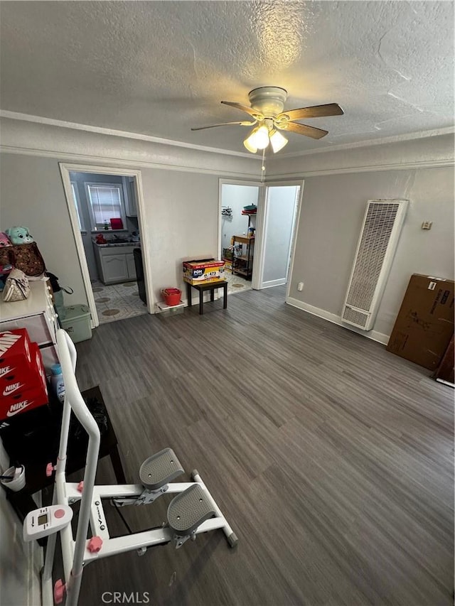 8648 Chestnut Ave, South Gate, CA 90280 - recreation room with a heating unit, ceiling fan, a textured ceiling, and wood finished floors