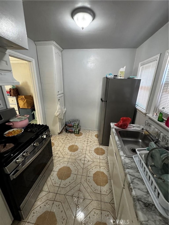 8648 Chestnut Ave, South Gate, CA 90280 - kitchen with stainless steel appliances, white cabinetry, range hood, and light tile patterned floors
