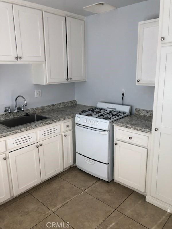19170 US Highway 18, Apple Valley, CA 92307 - kitchen featuring gas range gas stove, dark tile patterned floors, white cabinetry, and light stone countertops