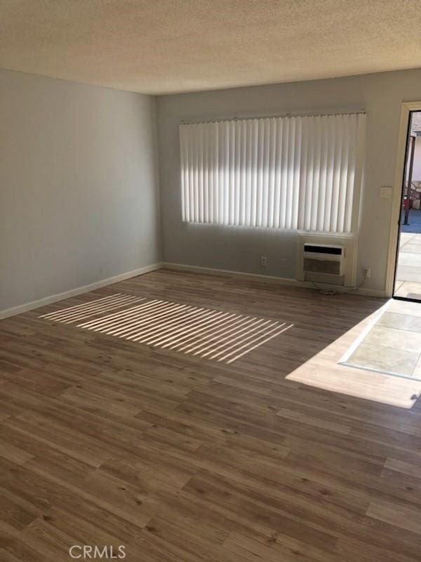 19170 US Highway 18, Apple Valley, CA 92307 - spare room featuring wood finished floors, a wall mounted air conditioner, and a textured ceiling