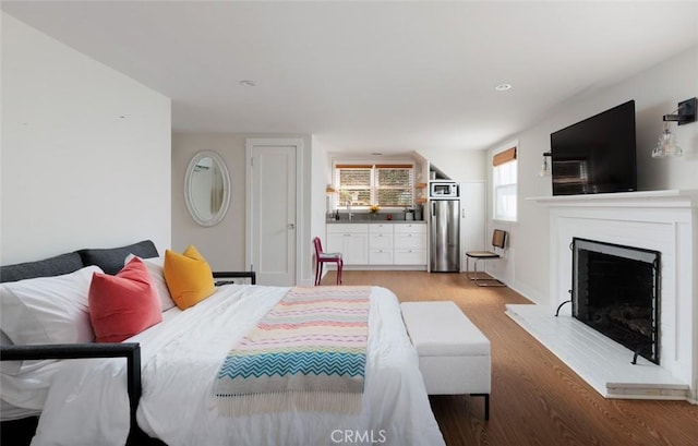 31907 9th Ave, Laguna Beach, CA 92651 - bedroom featuring light wood-style flooring, a fireplace with raised hearth, and stainless steel fridge