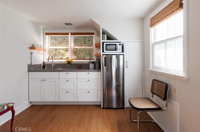 31907 9th Ave, Laguna Beach, CA 92651 - kitchen featuring open shelves, stainless steel fridge, light wood-style floors, white cabinetry, and white microwave