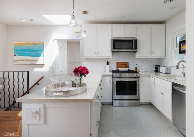31907 9th Ave, Laguna Beach, CA 92651 - kitchen with a skylight, appliances with stainless steel finishes, white cabinetry, light countertops, and tasteful backsplash
