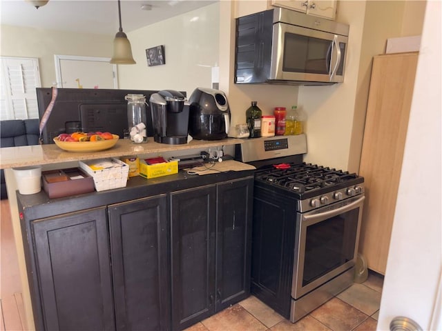 2432 N Eastern Ave, Los Angeles, CA 90032 - kitchen featuring stainless steel appliances, light tile patterned floors, pendant lighting, a peninsula, and light stone counters