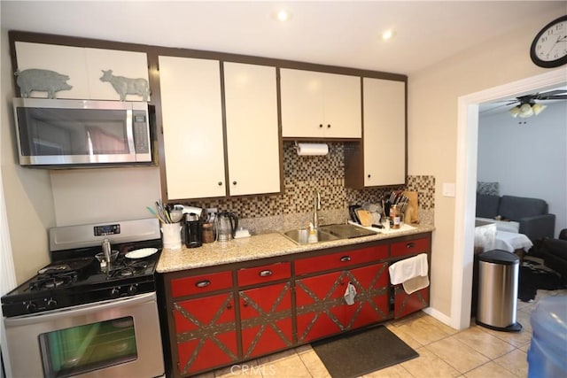 2432 N Eastern Ave, Los Angeles, CA 90032 - kitchen with stainless steel appliances, light countertops, decorative backsplash, light tile patterned floors, and white cabinets