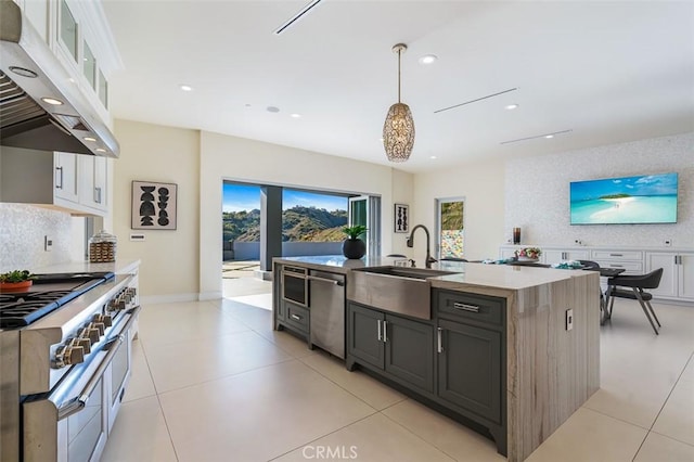 109 Buckskin Rd, Bell Canyon, CA 91307 - kitchen with ventilation hood, appliances with stainless steel finishes, decorative backsplash, a center island with sink, and white cabinetry