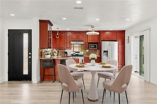 7751 La Mesa Way, Buena Park, CA 90620 - kitchen with light wood finished floors, hanging light fixtures, stainless steel appliances, a breakfast bar, and recessed lighting