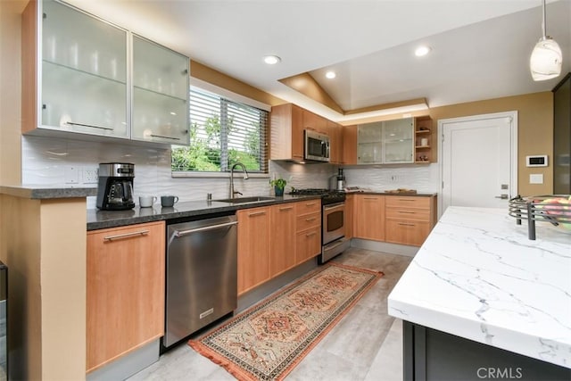 20516 Aetna St, Woodland Hills, CA 91367 - kitchen featuring stainless steel appliances, backsplash, dark stone counters, hanging light fixtures, and glass insert cabinets
