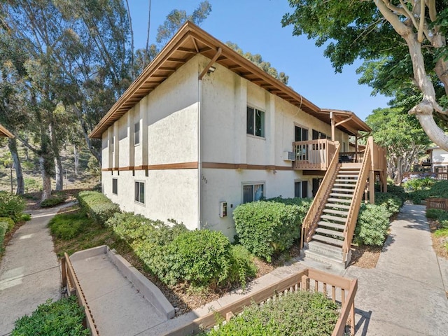 6390 Rancho Mission Rd Unit 202, San Diego, CA 92108 - view of property exterior featuring stucco siding, stairs, and a deck