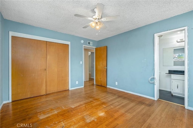 502 Tasman Ave, Pomona, CA 91767 - unfurnished bedroom with wood finished floors, a textured ceiling, a closet, connected bathroom, and a ceiling fan