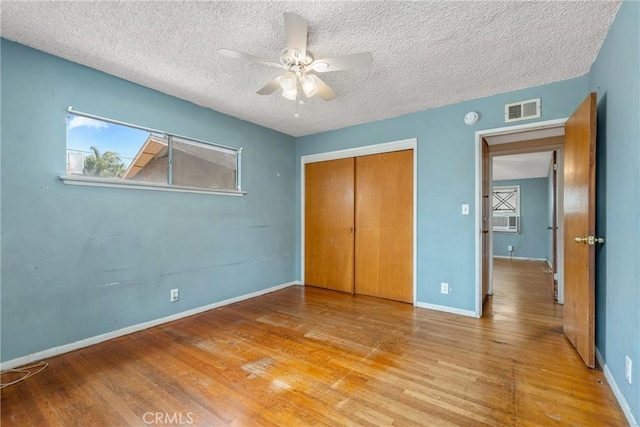 502 Tasman Ave, Pomona, CA 91767 - unfurnished bedroom with a textured ceiling, wood finished floors, a closet, ceiling fan, and cooling unit