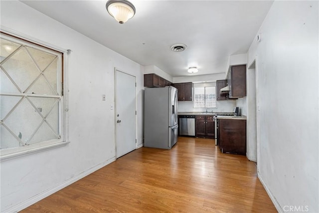 502 Tasman Ave, Pomona, CA 91767 - kitchen with stainless steel appliances, dark brown cabinets, light wood finished floors, and light countertops