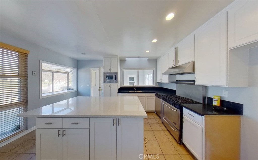 19128 Prairie St, Northridge, CA 91324 - kitchen featuring stainless steel appliances, exhaust hood, white cabinets, a kitchen island, and recessed lighting