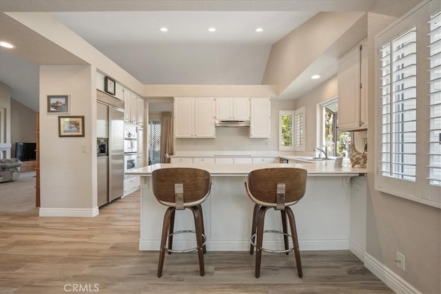 81 Via Larga Vis, Bonsall, CA 92003 - kitchen with built in fridge, a peninsula, light countertops, plenty of natural light, and recessed lighting