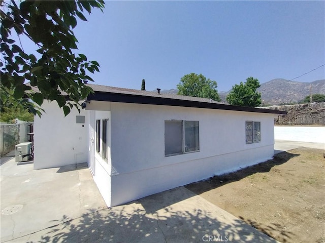 13410 Berg St, Sylmar, CA 91342 - view of side of property with a patio area, a mountain view, and stucco siding