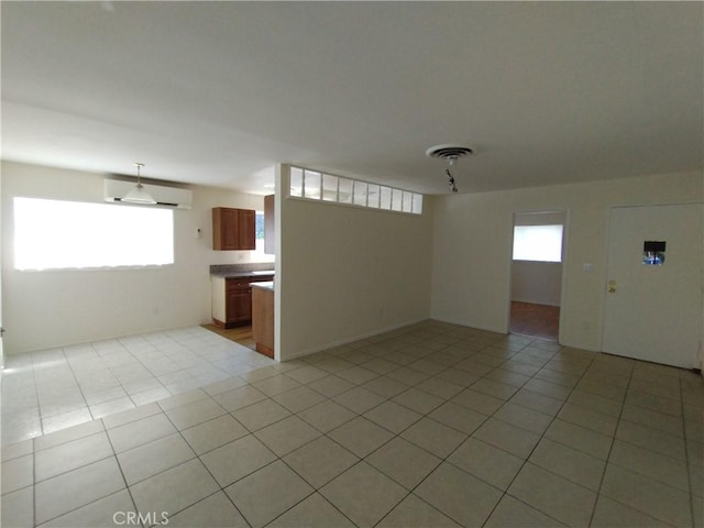 13410 Berg St, Sylmar, CA 91342 - unfurnished living room with healthy amount of natural light, light tile patterned flooring, and a wall mounted air conditioner