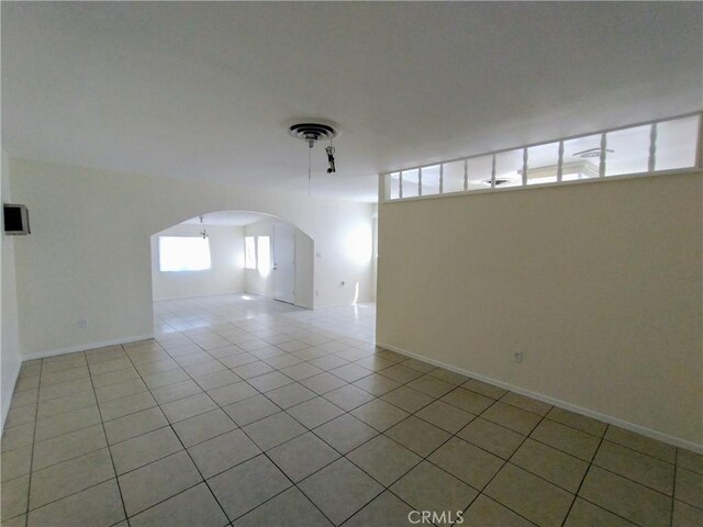 13410 Berg St, Sylmar, CA 91342 - tiled spare room featuring arched walkways and baseboards