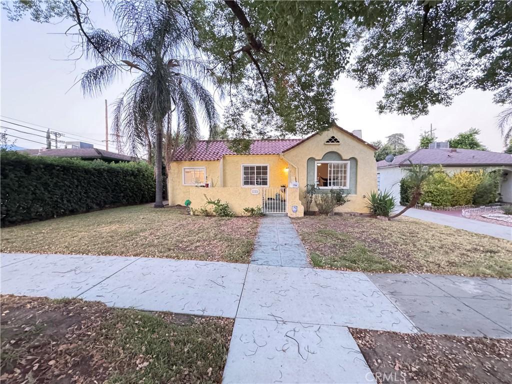 2783 N Arrowhead Ave, San Bernardino, CA 92405 - mediterranean / spanish home with a fenced front yard, stucco siding, a chimney, a tile roof, and a gate