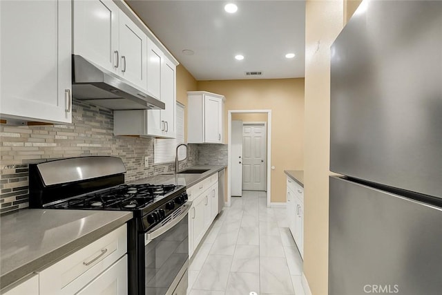 13203 Gyna Ln, La Puente, CA 91746 - kitchen with appliances with stainless steel finishes, under cabinet range hood, light marble finish flooring, white cabinets, and tasteful backsplash
