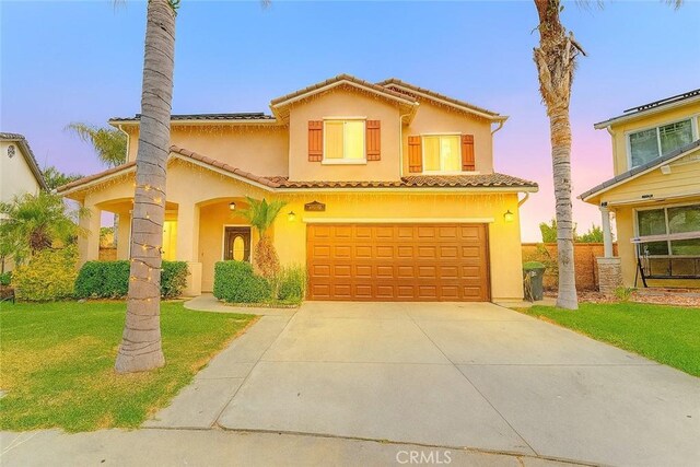 13203 Gyna Ln, La Puente, CA 91746 - mediterranean / spanish house featuring concrete driveway, an attached garage, stucco siding, a front yard, and a tile roof
