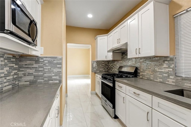 13203 Gyna Ln, La Puente, CA 91746 - kitchen featuring stainless steel appliances, under cabinet range hood, white cabinets, tasteful backsplash, and light marble finish flooring