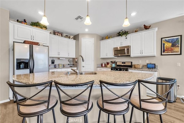 11444 River Run St, Apple Valley, CA 92308 - kitchen featuring light wood finished floors, stainless steel appliances, white cabinets, a kitchen island with sink, and recessed lighting