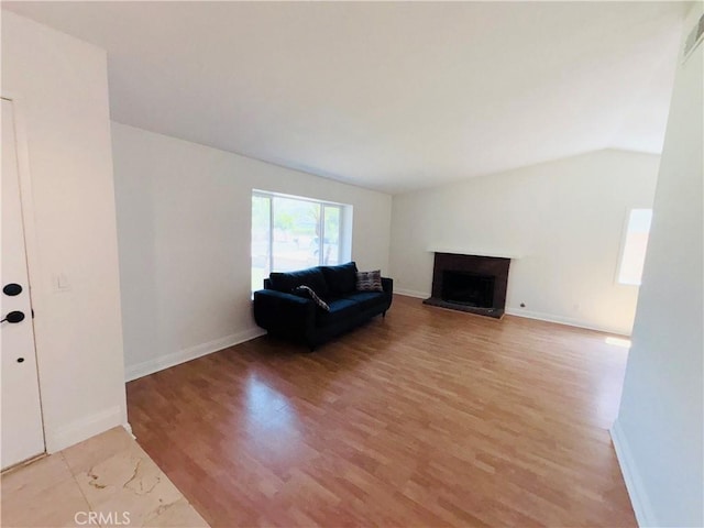 10349 Victoria St, Rancho Cucamonga, CA 91701 - living area featuring light wood-style floors, a fireplace with raised hearth, and vaulted ceiling