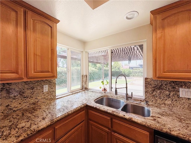 10349 Victoria St, Rancho Cucamonga, CA 91701 - kitchen featuring backsplash, brown cabinetry, and light stone countertops