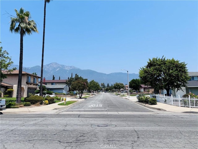 10349 Victoria St, Rancho Cucamonga, CA 91701 - view of asphalt road with sidewalks, a mountain view, curbs, and a residential view