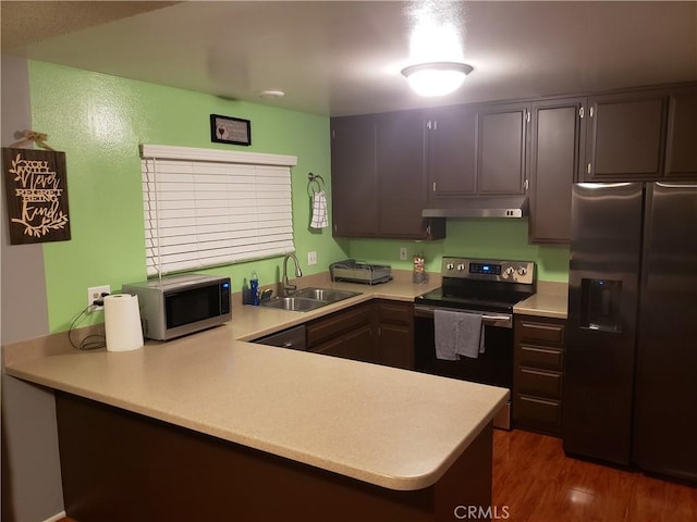 811 Cinnamon Ln, Duarte, CA 91010 - kitchen featuring stainless steel appliances, under cabinet range hood, light countertops, a peninsula, and wood finished floors