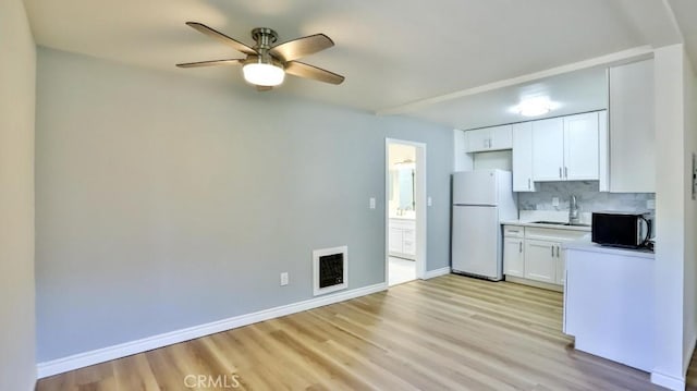 1000 W Macarthur Blvd Unit 57, Santa Ana, CA 92707 - kitchen with freestanding refrigerator, light wood-style floors, ceiling fan, and backsplash