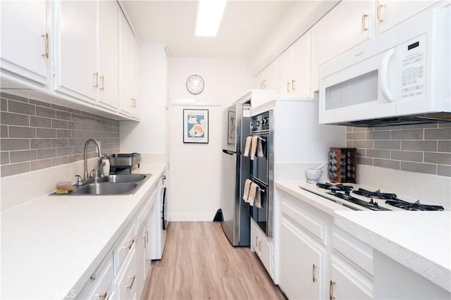 6160 Whitsett Ave Unit 4, North Hollywood, CA 91606 - kitchen featuring white appliances, light wood-style floors, white cabinetry, and backsplash