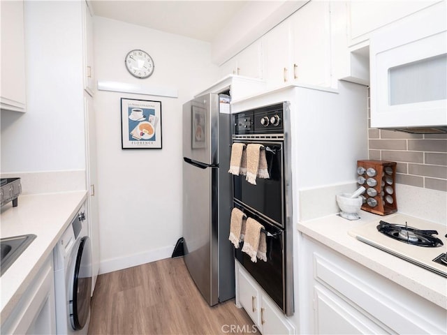 6160 Whitsett Ave Unit 4, North Hollywood, CA 91606 - kitchen with freestanding refrigerator, washer / dryer, light countertops, light wood finished floors, and white cabinetry