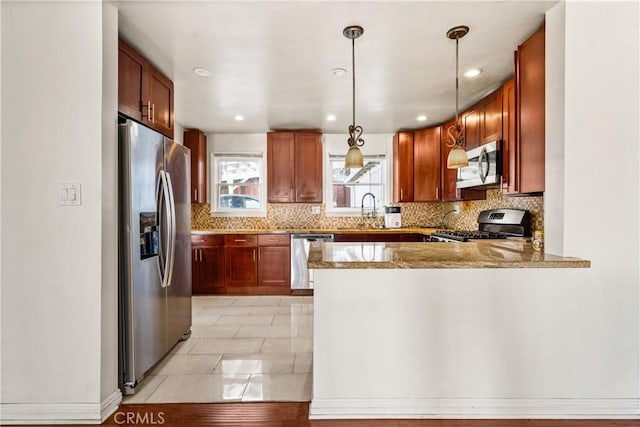 7314 Summitrose St, Tujunga, CA 91042 - kitchen with stainless steel appliances, a peninsula, tasteful backsplash, light stone counters, and decorative light fixtures