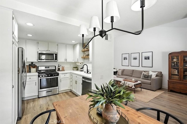 24754 Masters Cup Way, Valencia, CA 91355 - kitchen with appliances with stainless steel finishes, light wood-style flooring, light countertops, white cabinets, and open floor plan