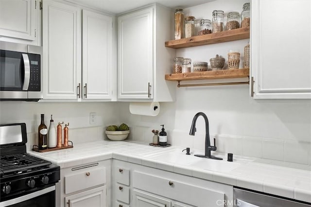 24754 Masters Cup Way, Valencia, CA 91355 - kitchen with stainless steel microwave, gas stove, white cabinetry, and dishwasher