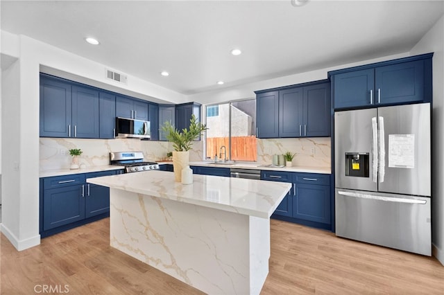 827 La Cadena Ln, Corona, CA 92879 - kitchen featuring stainless steel appliances, blue cabinets, light wood-style floors, light stone counters, and recessed lighting