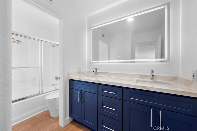 827 La Cadena Ln, Corona, CA 92879 - full bathroom featuring double vanity, wood finished floors, and combined bath / shower with glass door