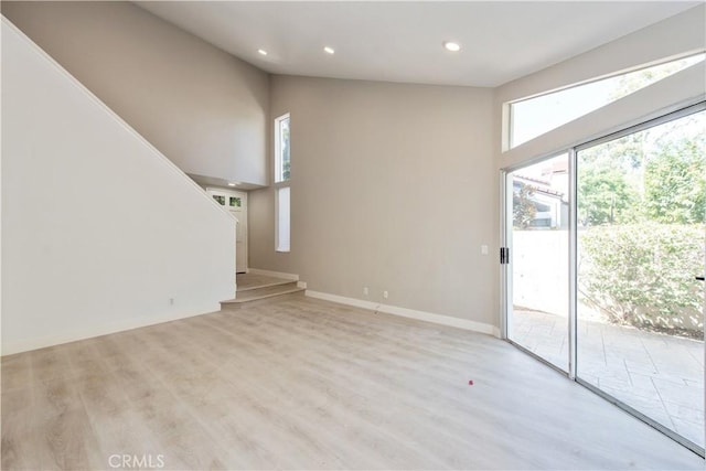 29 Stanford Ct Unit 93, Irvine, CA 92612 - unfurnished living room featuring a towering ceiling, light wood-type flooring, and recessed lighting