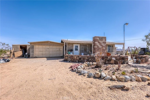 72082 Winters Rd Unit 29, Palms, CA 92277 - view of front of property featuring a garage, driveway, and stone siding