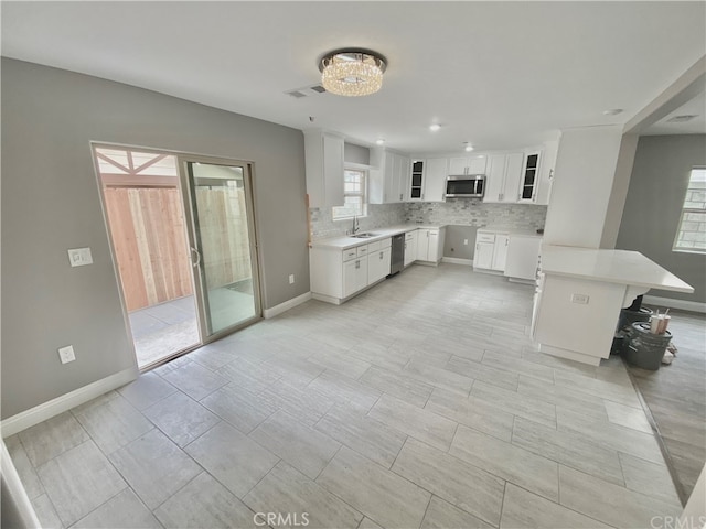 6545 Newlin, Whittier, CA 90601 - kitchen featuring appliances with stainless steel finishes, decorative backsplash, light countertops, white cabinetry, and glass insert cabinets