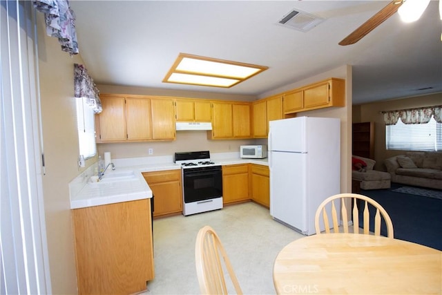 21295 Wisteria St, Apple Valley, CA 92308 - kitchen featuring white appliances, under cabinet range hood, tile countertops, ceiling fan, and light floors